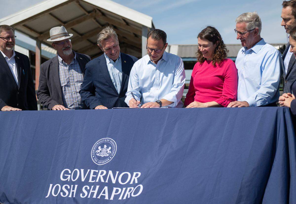 Pennsylvania Governor Josh Shapiro does a ceremonial signing of the $10 million Agriculture Innovation Grant Program while next to Rep. Paul Takac at Penn State’s Dairy Research and Teaching Complex on Monday, Sept. 16, 2024.