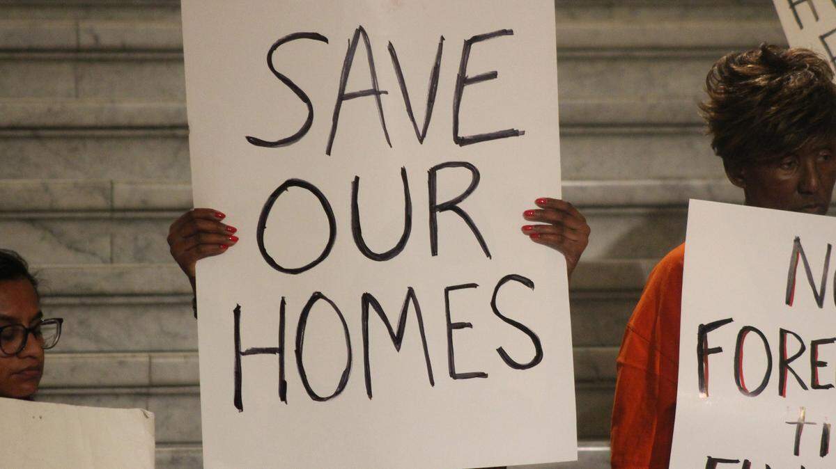 Advocates holdings signs at the State Capital.