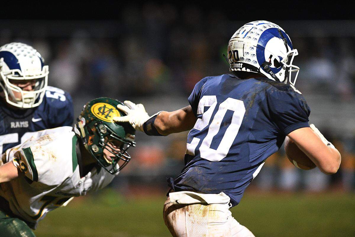 Penns Valley’s Logan Snyder (20) straight-arms Marion Center defender Hunter Lydic (left) during Saturday night’s PIAA District  6 football playoffs at Penns Valley.  (For the CDT/Steve Manuel)