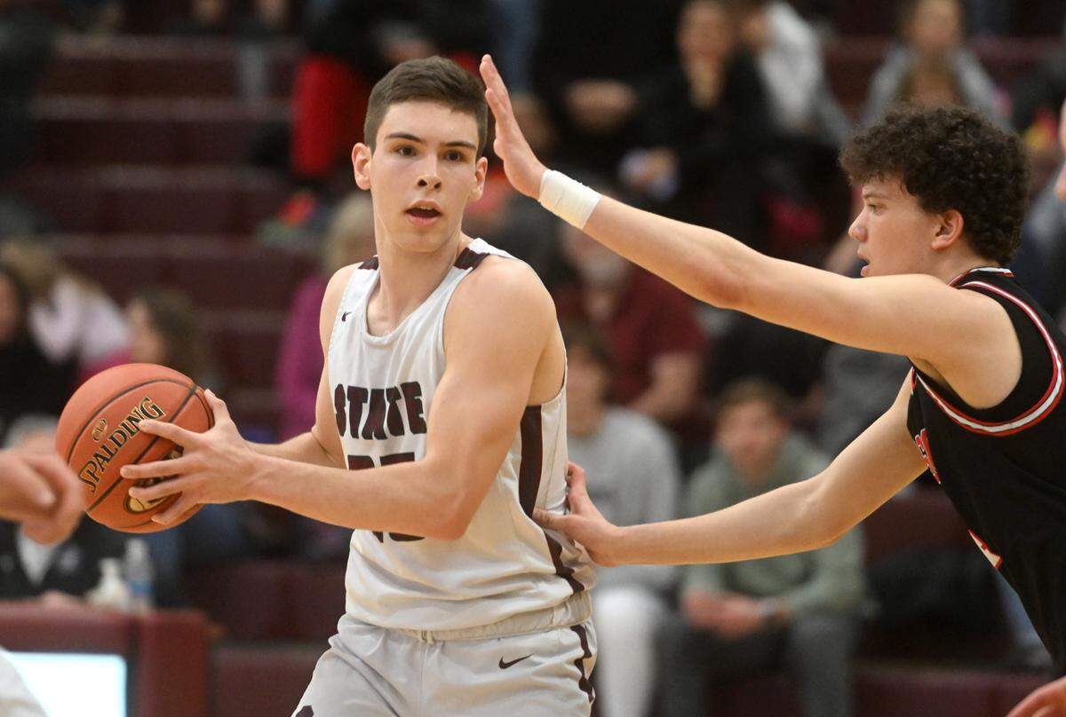 State College’s Isaac Dye looks for a teammate to pass to around an Upper St. Clair defender during the PIAA first round game on Saturday, March 11, 2023. State College won, 72-42.