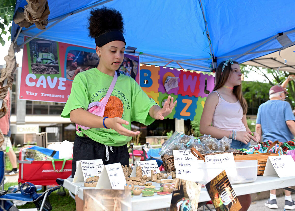 Olivia Wigfield, 11, gives a sales pitch about her cave clay-created figures during the Children and Youth Day sidewalk sale at the Central Pennsylvania Festival of the Arts on Wednesday, July 8, 2026. Wigfield and her friend Izzy DiPlacadio’s booth “Cave Critters” features animals made from clay they collected around Woodward Cave.