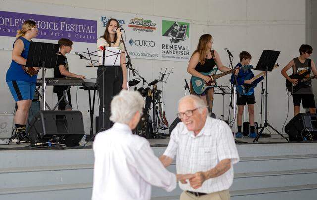 A couple dances as State College Rock Camp performs at the People’s Choice Festival on Friday, July 14, 2023.