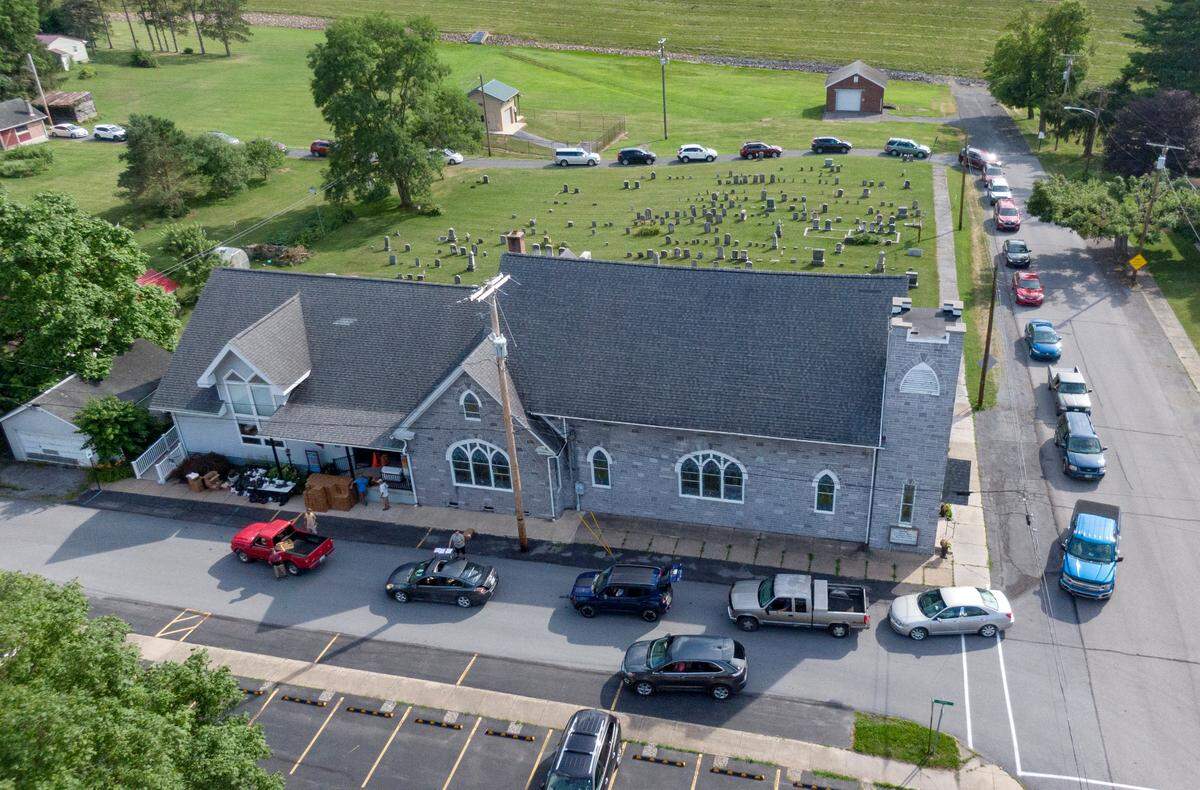 Cars line up around the block for the YMCA food distribution at the Howard United Methodist Church on Thursday, July 7, 2022.