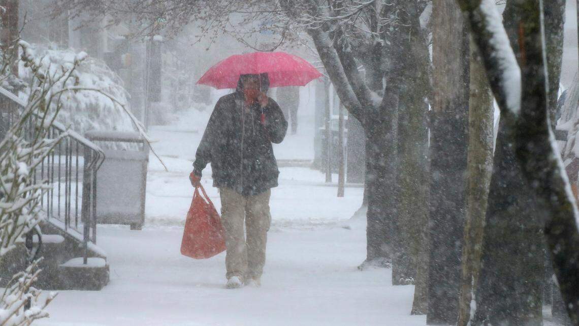 A man walks through Lancaster City with his shopping bag during a snowstorm March 12.