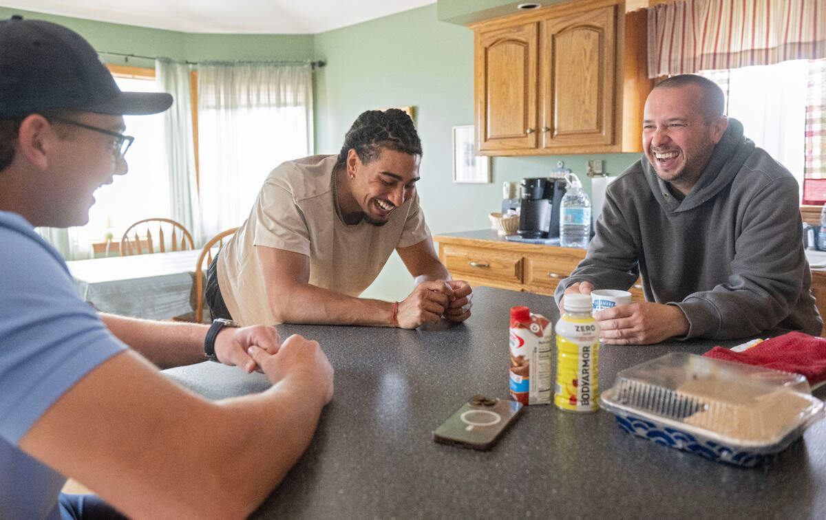 Frank Kachurak, right, jokes around with State College Spikes players Ahmad Harajli and Jakobi Davis around the island in his kitchen on Thursday, July 17, 2025.