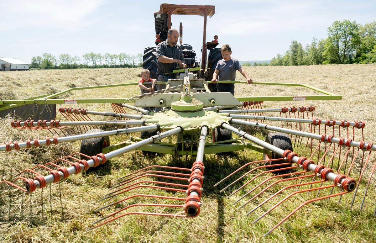 Darren King makes some adjustments with the help of two of his sons Landon, 4 and Kenton, 12, as they prep a field of hay at Stem to Stable Farm on Tuesday, May 21, 2024.