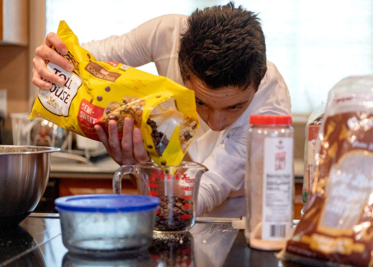 Yunus Alptekinoglu carefully measures the chocolate chips for almond flour cookies on July 23.