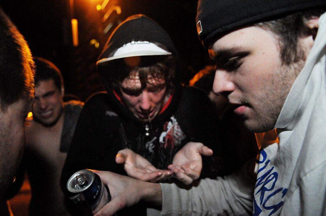 Rioters rinse their faces with beer to relieve pain after being pepper sprayed during a riot on Beaver Avenue after PennState’s victory over Ohio State in October 2008.