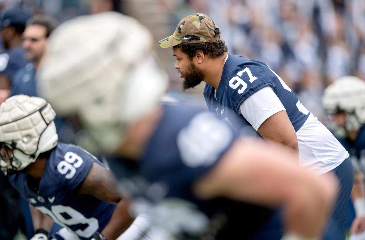 Penn State defensive tackle PJ Mustipher does some warm ups with teammates before the Blue-White game on Saturday, April 23, 2022.