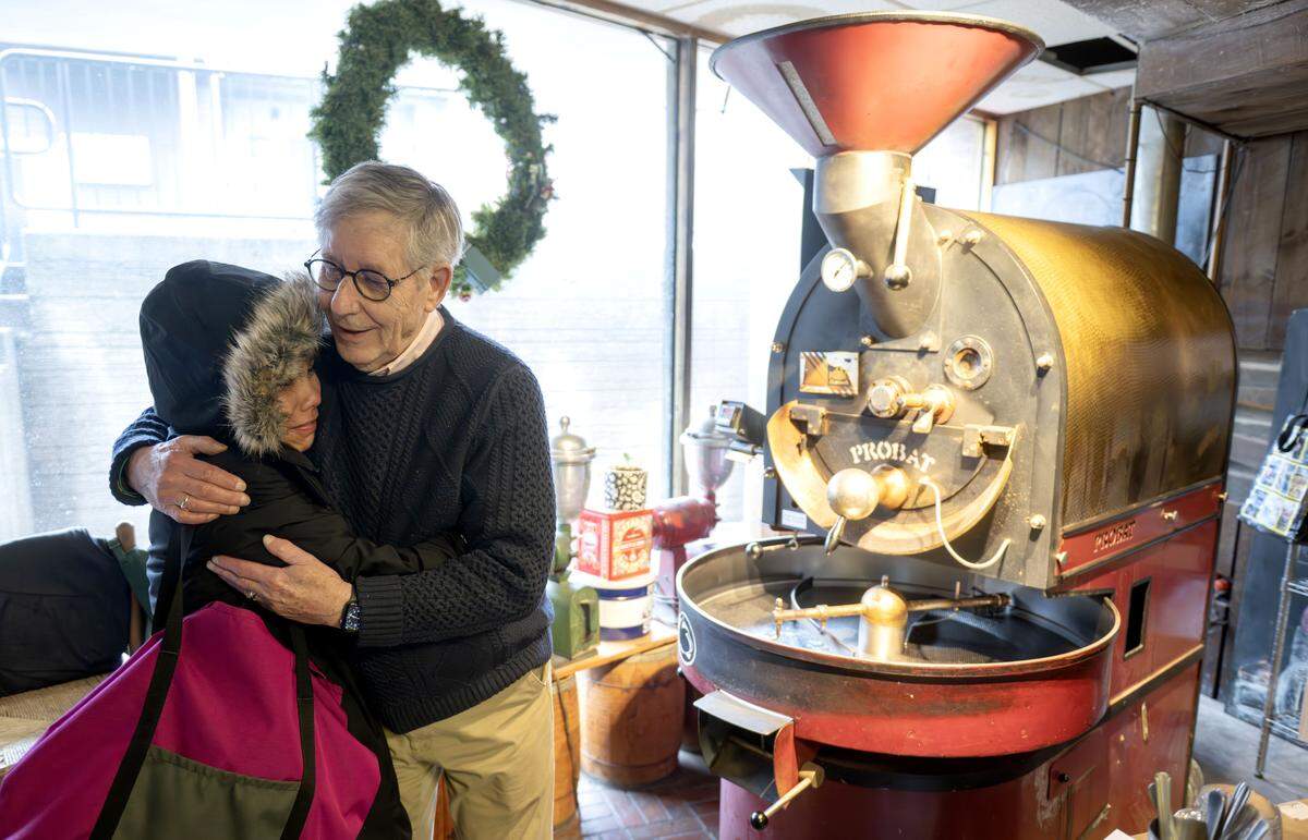 Bill Clarke hugs a customer as he roasts coffee beans at The Cheese Shoppe on Wednesday, March 4, 2026. 