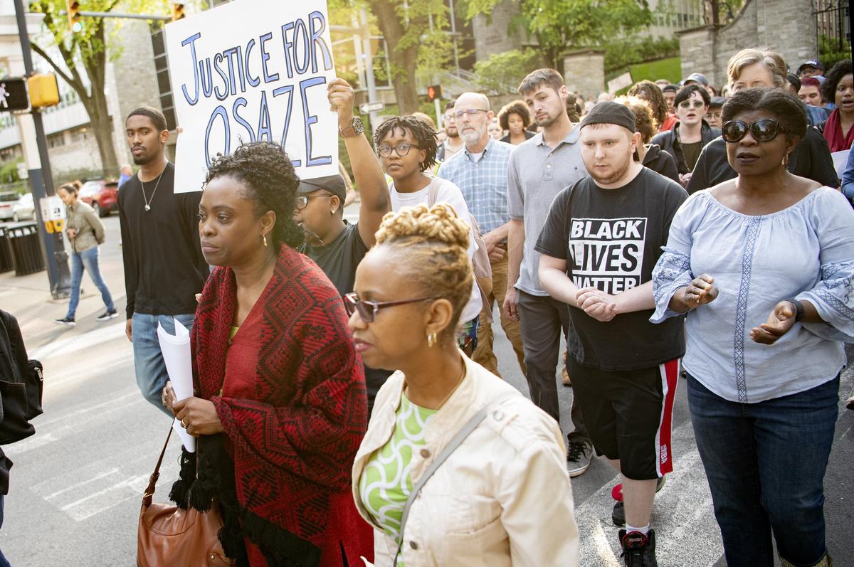 Iyunolou Osagie, Osaze Osagie’s mother, and a crowd of community members walk up Allen Street in downtown State College on Wednesday evening. Osaze was shot by police on March 20, 2019 after the officers went to his apartment to serve a mental health warrant.