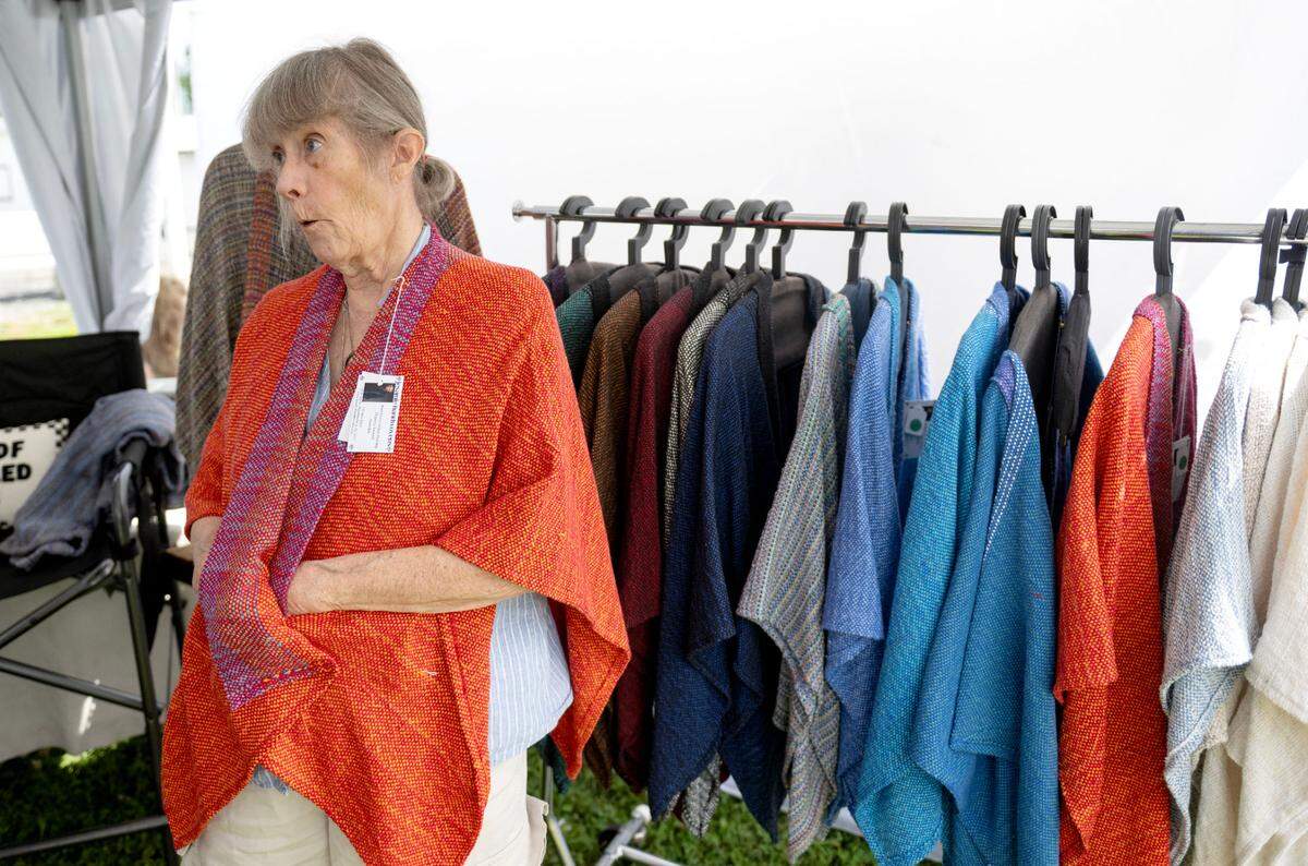 Pamela Bartl shows how her handwoven cotton shawl has pockets during the People’s Choice Festival of Pennsylvania on Thursday, July 10, 2025.