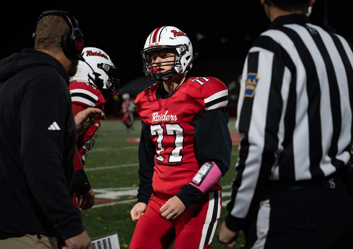 Bellefonte’s William Oskin (77) gets advice from his coach during a Friday night football game against Greater Johnstown in Bellefonte, Pa., on Oct. 31, 2025. The Red Raiders beat the Trojans 34-0.