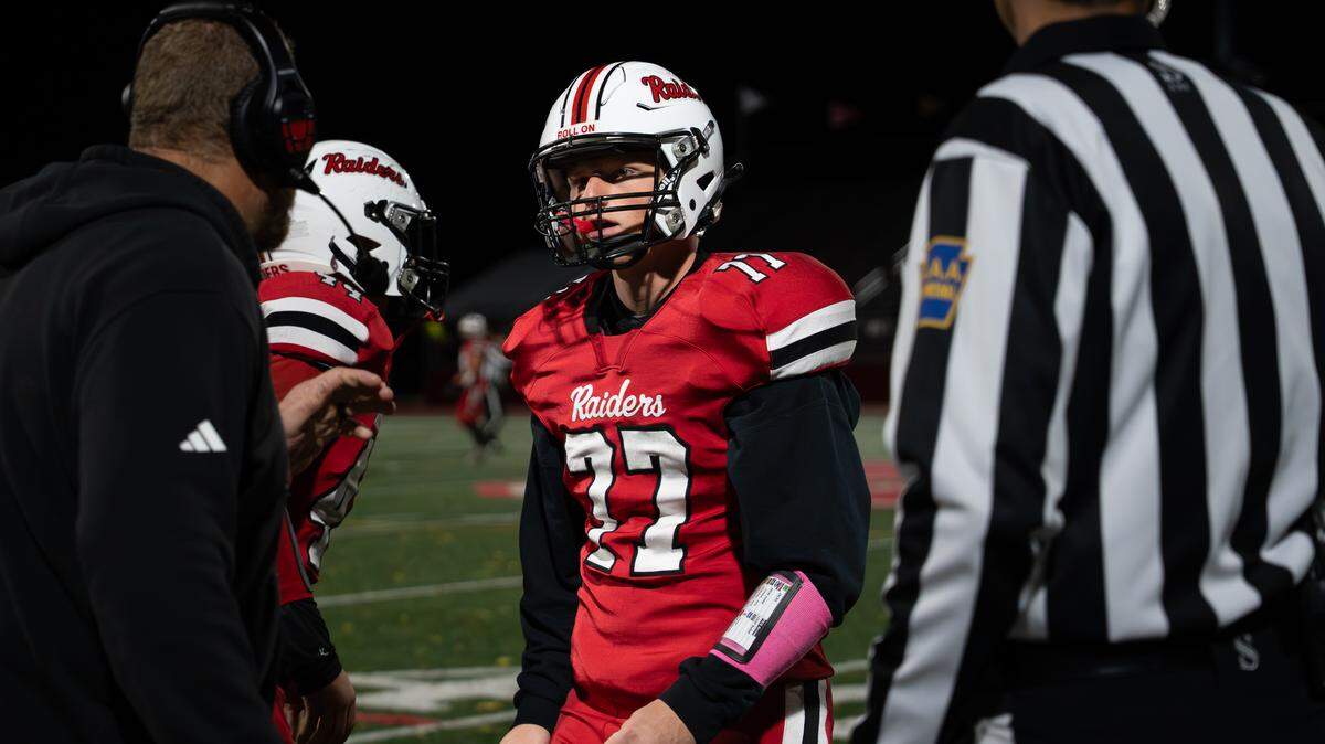 Bellefonte’s William Oskin (77) gets advice from his coach during a Friday night football game against Greater Johnstown in Bellefonte, Pa., on Oct. 31, 2025. The Red Raiders beat the Trojans 34-0.