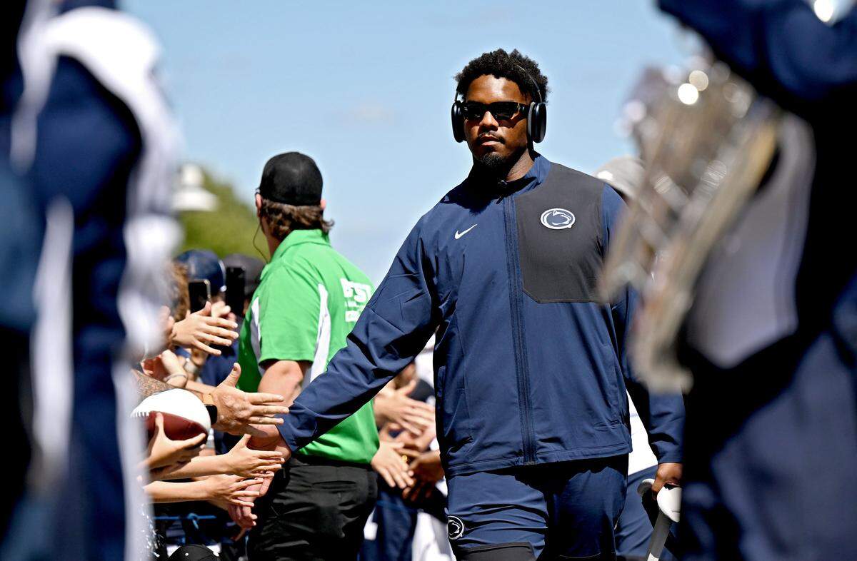 Penn State defensive end Dani Dennis-Sutton high-fives fans as he and the team arrive at Beaver Stadium for the season opener on Saturday, Aug. 30, 2025.  