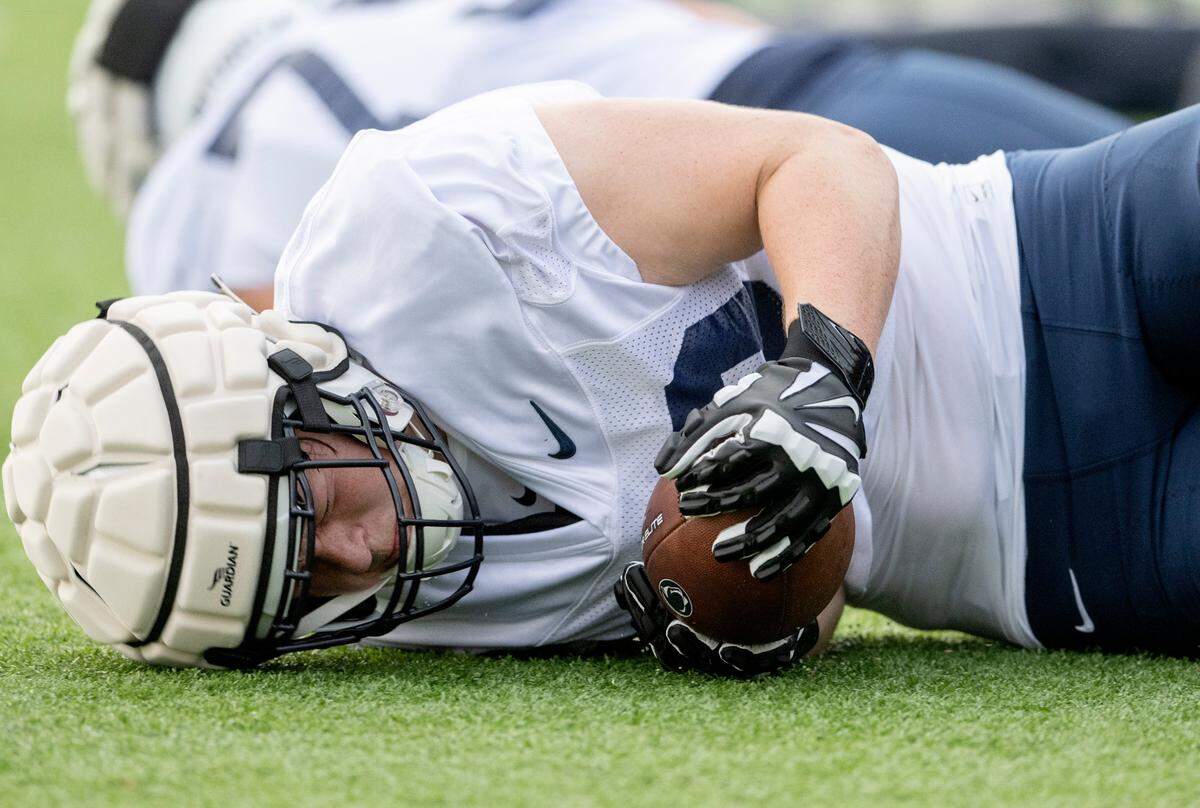 Penn State offensive lineman Ben Hartman dives on a ball for a drill during the first day of practice on Monday, Aug. 1, 2022.