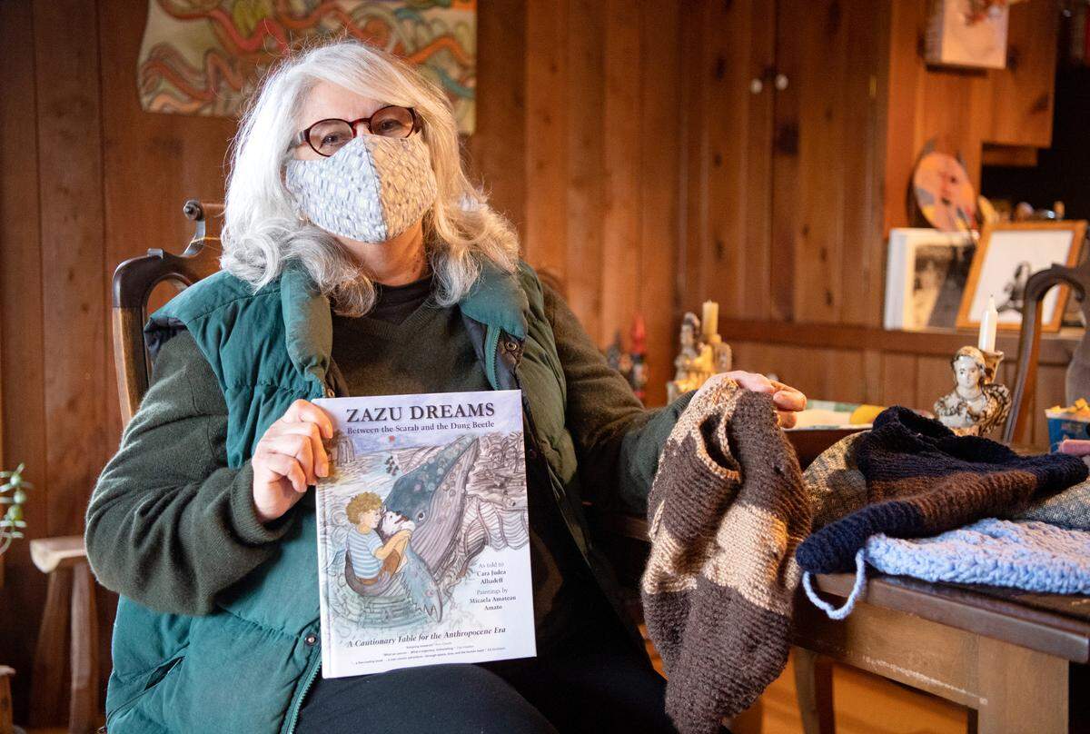 Micaela Amateau in her home with a book she worked on with her daughter, and some of her crocheted produce bags. Amateau advocates for the community to use less plastic.