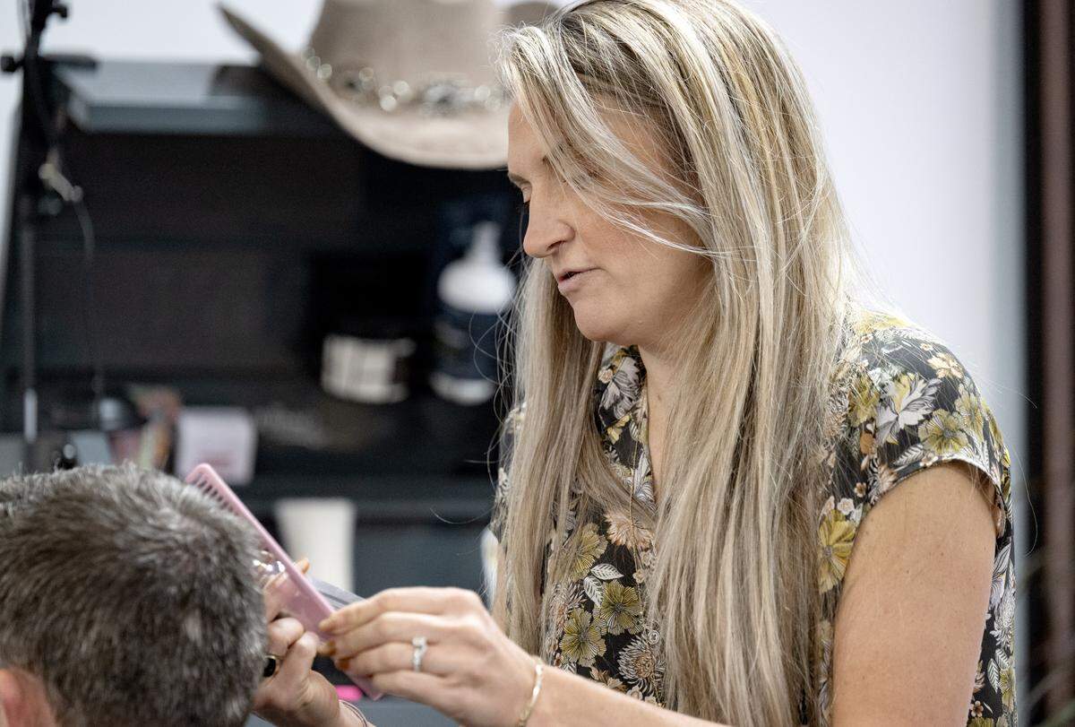 Tanya Campbell chats with a client while cutting his hair at the Whiskey Barber Salon on Thursday, April 30, 2026.  