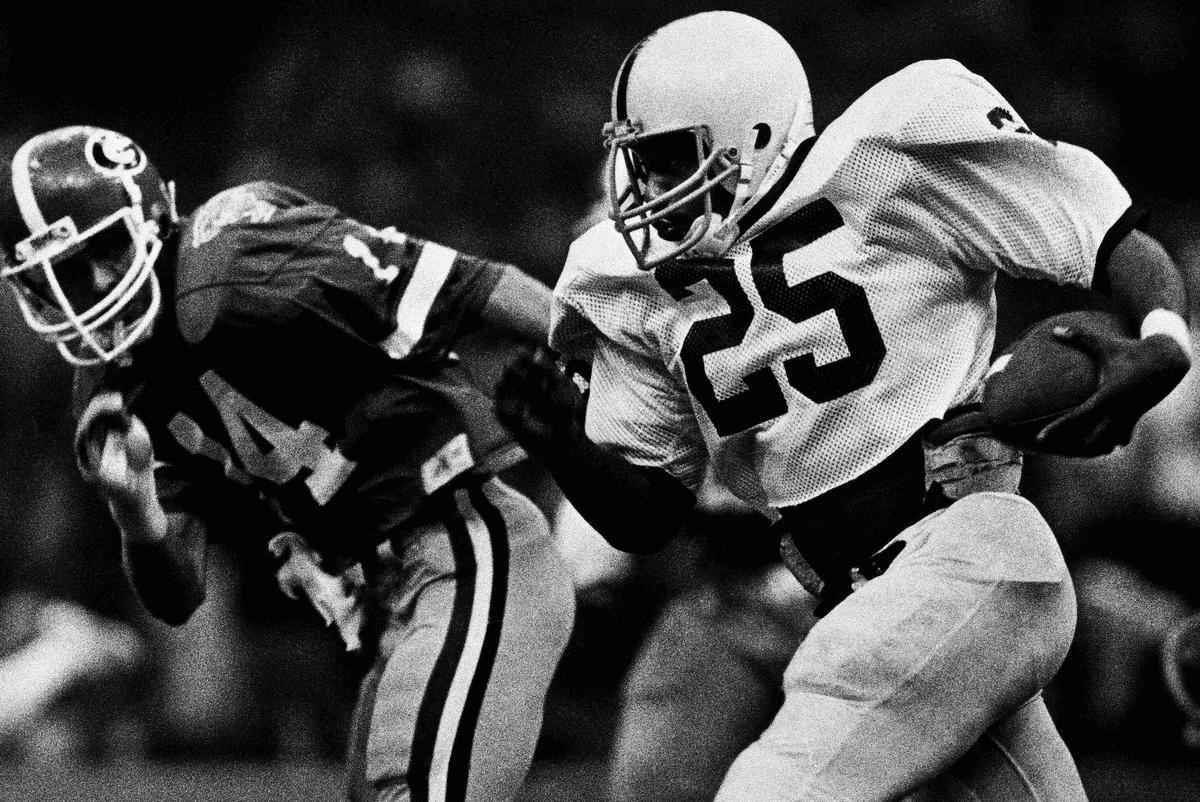 Penn State tailback Curt Warner steps out on a carry with Georgia's All-American Terry Hoage giving chase in the Sugar Bowl in 1983. (AP Photo).
