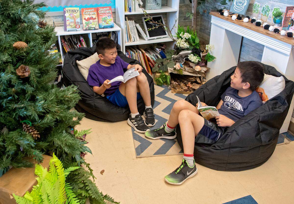 Friends in Ali Davenport’s third grade classroom laugh as they read together at Ferguson Township Elementary School on Wednesday, May 11, 2022.