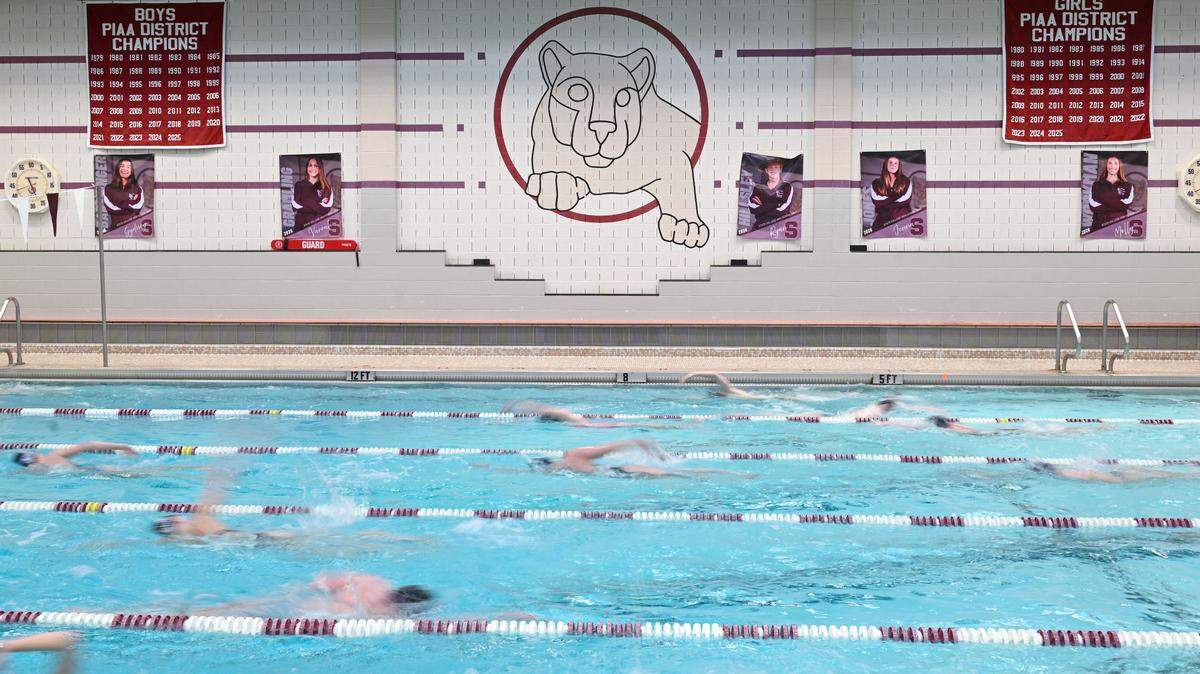 The State College swim team practices on Thursday, March 5, 2026. Banners hang on the wall listing all the district championships.