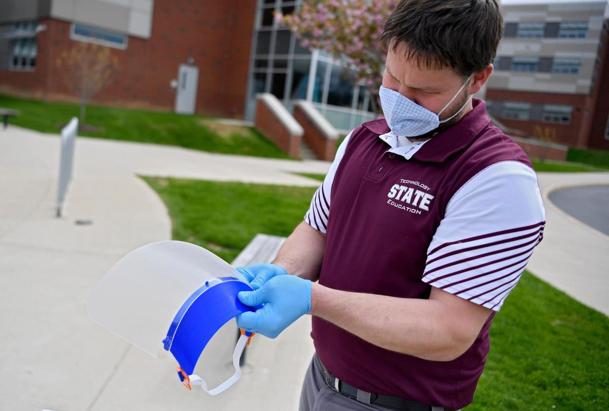 Jason Donaldson, technology education teacher at State College Area High School, clips together a face shield that will be donated to local organizations.