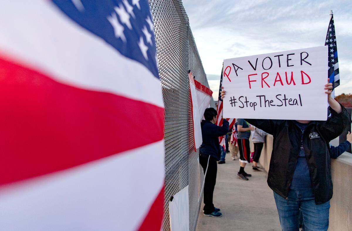 Trump supporters gather on the Waddle Road interchange on Thursday for a “Stop the Steal” rally.