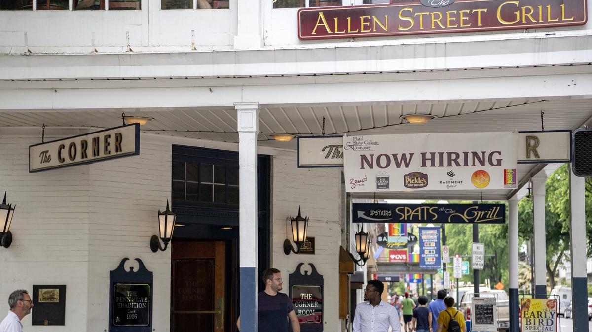 A sign promoting the restaurants and bars of Hotel State College that are hiring hangs over The Corner Room sign on Friday, June 7, 2019.