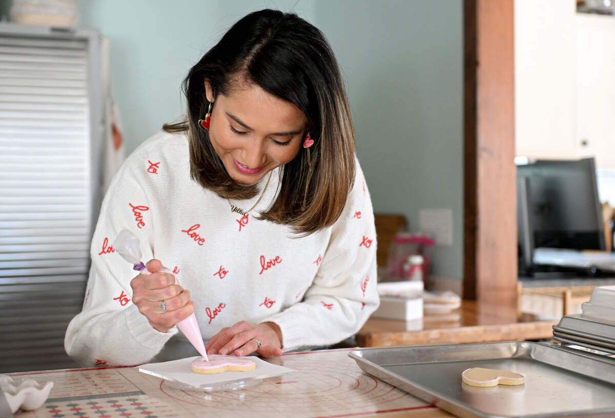 Yilka Thompson of Yilka’s Baking Studio decorates a heart shaped cookie on Friday, Jan. 23, 2026.