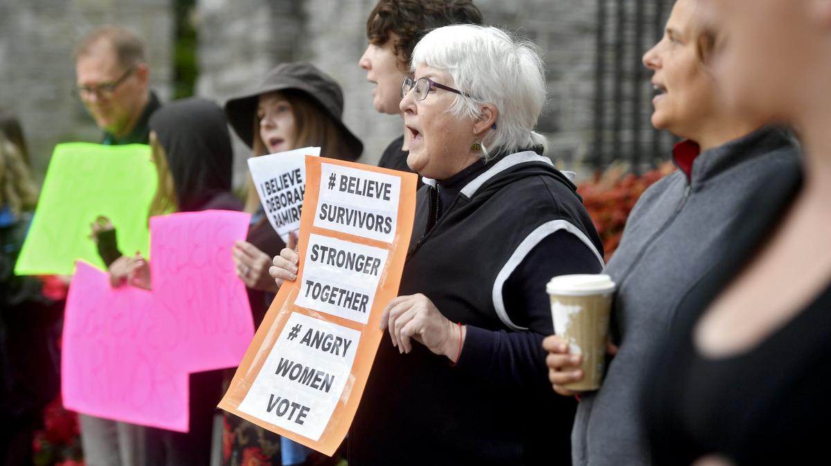 Joy Mitra, one of the founders of the women’s studies program at the University of Pittsburgh, holds a sign as she chants with the crowd gathered at the Allen Street gates as part of the national walkout in solidarity with survivors of sexual violence on Monday, Sept. 24, 2018.