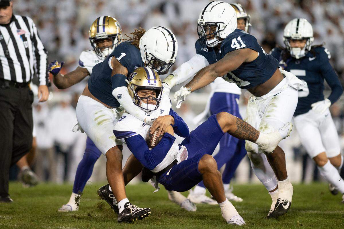 Washington quarterback Dmond Williams Jr. (2) is tackled by Penn State safety Jaylen Reed (1) and linebacker Kobe King (41) during the football game at Beaver Stadium on Saturday, Nov. 9, 2024.