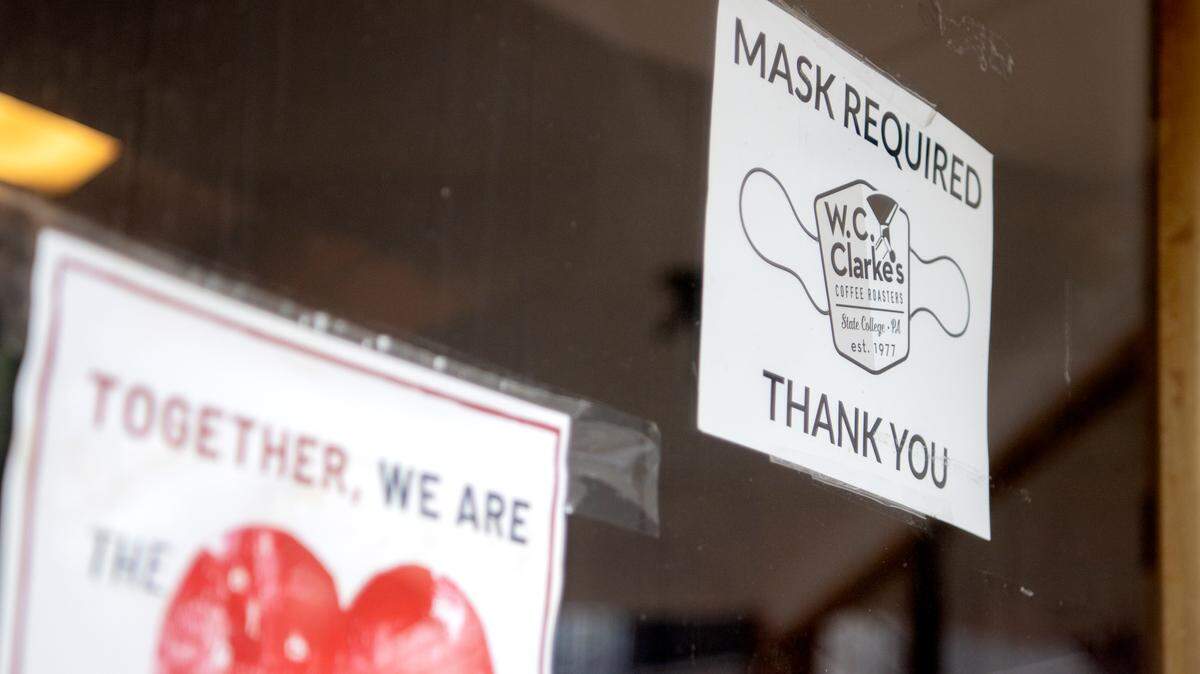 A masks required sign hangs on the window at The Cheese Shoppe. State College’s masking ordinance has been extended through Dec. 7.