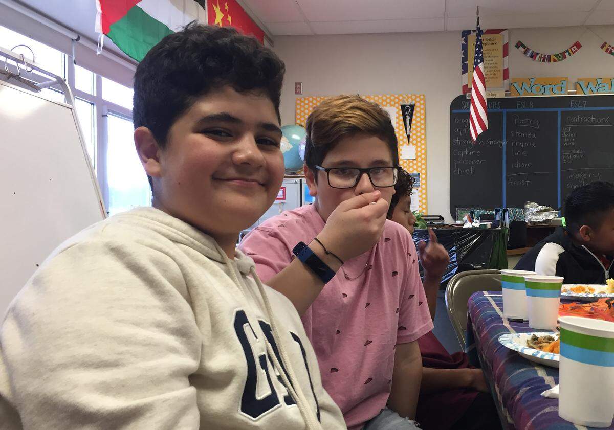 Mount Nittany Middle School seventh graders Abdallah Alrababah and Haitham Hayajneh enjoy a Thanksgiving meal. The two friends are both from the same city in Jordan but only met when their families moved to State College.