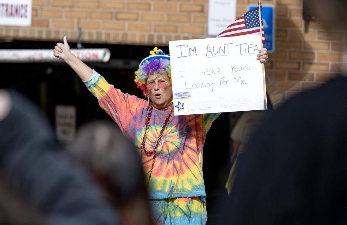 Laurie cheers on fellow protesters along Fraser Street during the No Kings anti-Trump rally on Saturday, Oct. 18, 2025. 