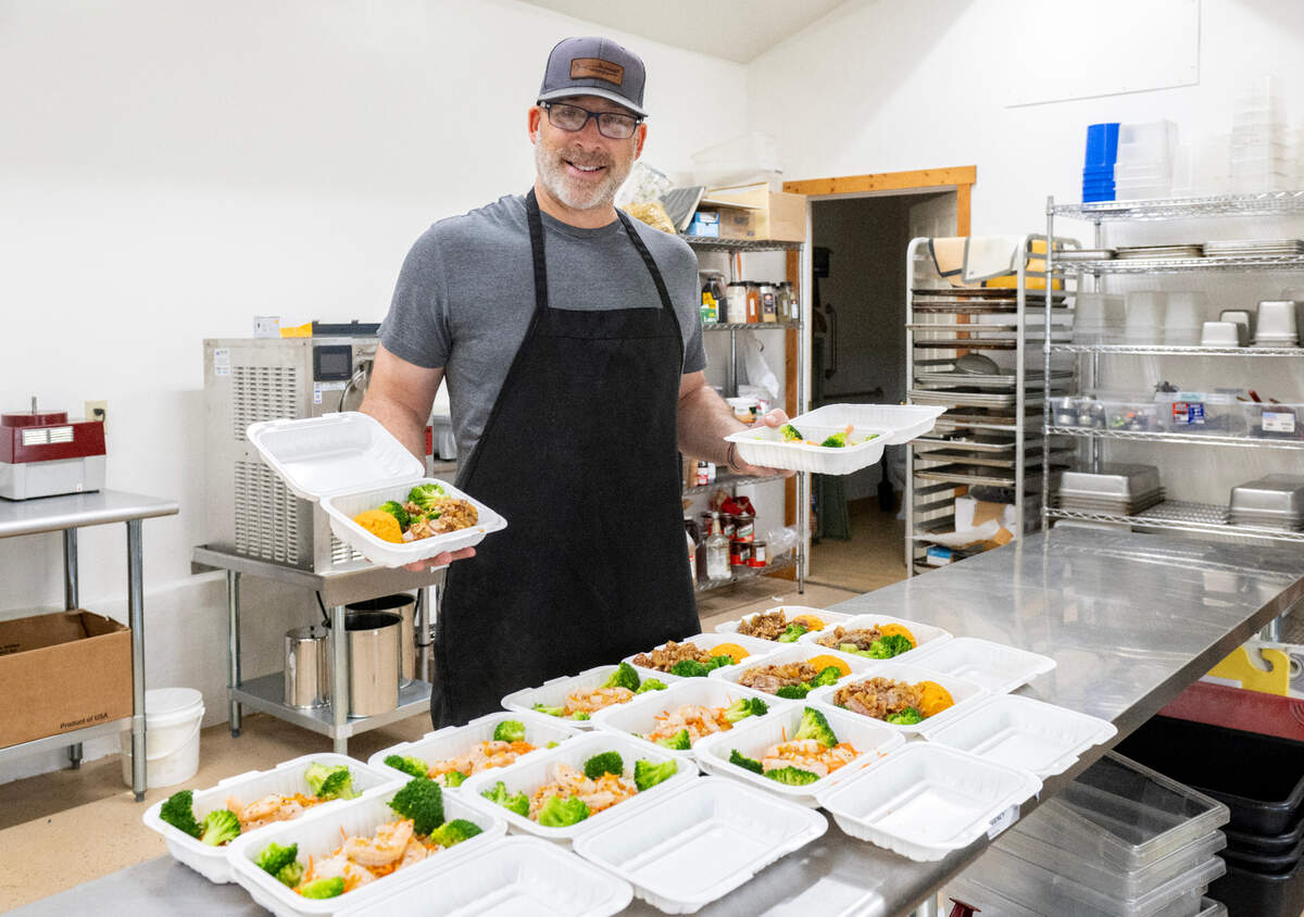 Justin Leiter of Belle City Bites hold a pork tenderloin meal and a orange ginger shrimp meal on Monday, June 9, 2025.