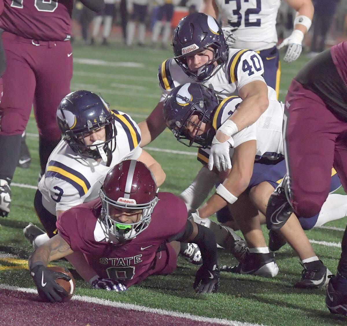 State College’s D'Antae Sheffey drags some Central Catholic defenders into the end zone to score a touchdown in the first quarter of the PIAA Class 6A quarterfinal game Friday, Nov. 21, 2025, at Altoona’s Mansion Park.