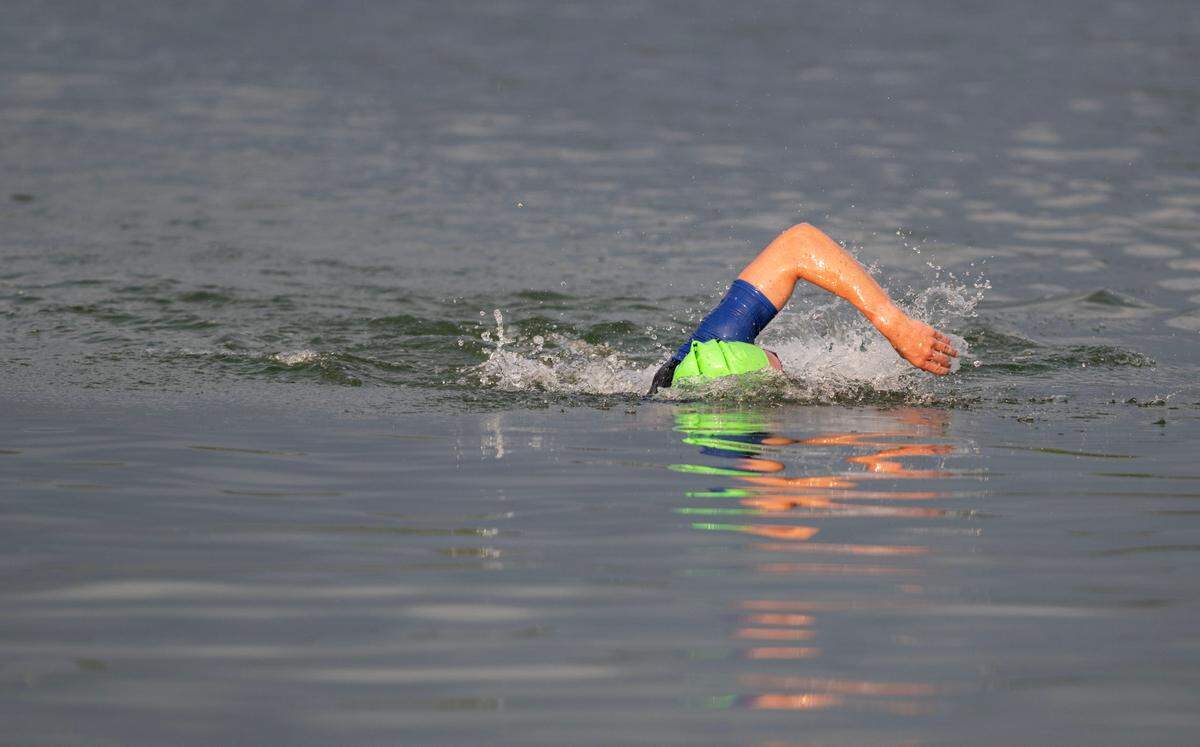 The first swimmer approaches the shore after the 1.2 mile swim in Foster Joseph Sayers Lake at Bald Eagle State Park for the Ironman 70.3 Pennsylvania Happy Valley on Sunday, June 30, 2024.