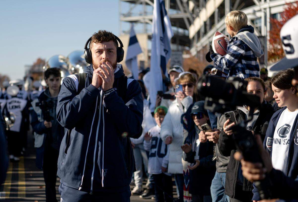 Penn State quarterback Sean Clifford blows on his hands as he and the team arrive at Beaver Stadium for the game against Ohio State on Saturday, Oct. 29, 2022.