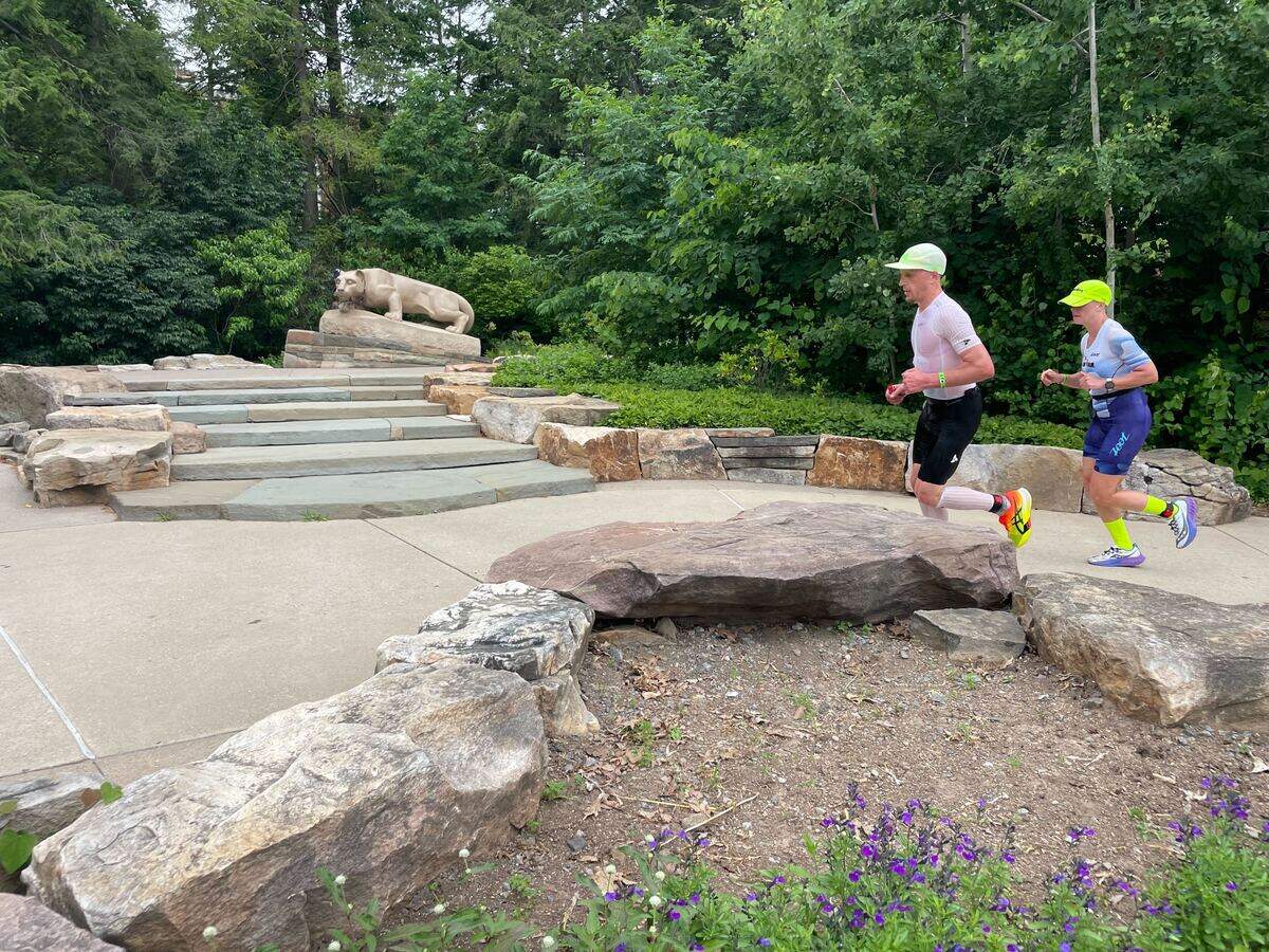 Two participants run past the Nittany Lion statue on Penn State’s campus Sunday, June 14, 2026, at the Ironman 70.3 Pennsylvania Happy Valley North American Championship in Centre and Clinton counties.