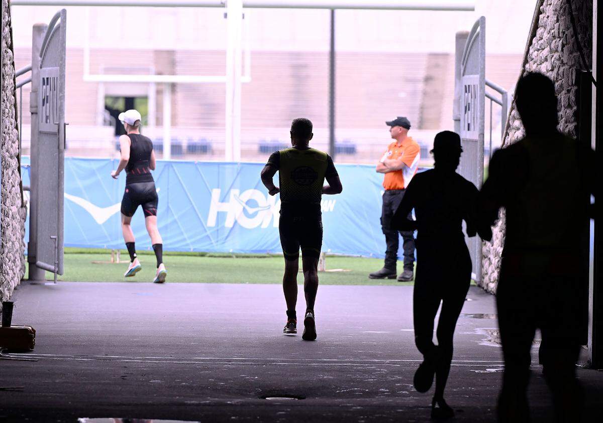 Participants in the Ironman 70.3 Pennsylvania Happy Valley triathlon run through the South end zone tunnel of Beaver Stadium to the finish line Sunday.