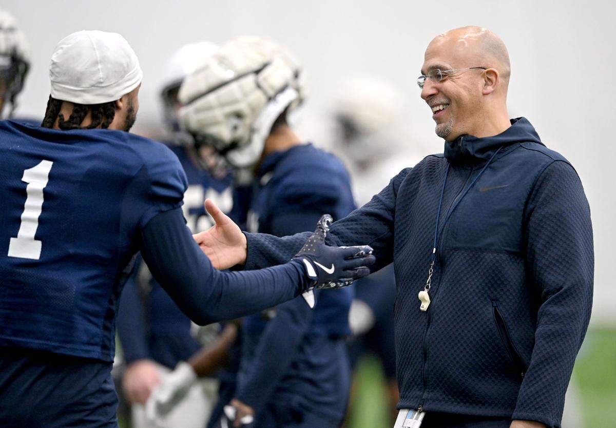 Penn State football coach James Franklin laughs and high-fives safety Jaylen Reed during practice on Friday, Dec. 27, 2024 at Holuba Hall.