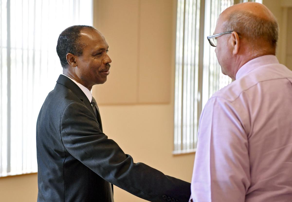 Sylvester Osagie shakes hands with State College Assistant Borough Manager of Public Safety Tom King after the press conference on Thursday.