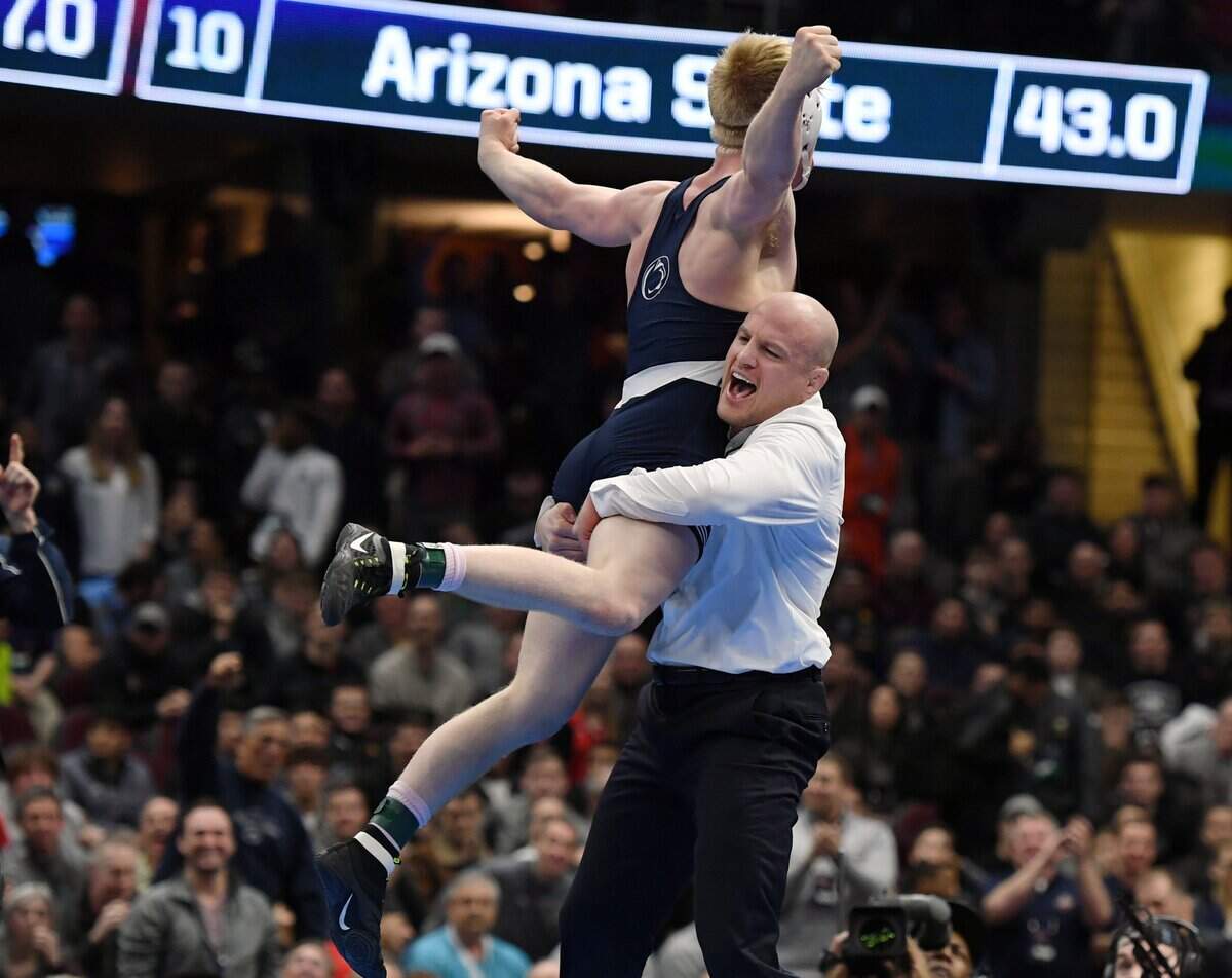 Penn State’s Bo Nickal jumps into head wrestling coach Cael Sanderson’s arms after pinning Ohio State’s Myles Martin in the 184 pounds finals during the NCAA Division I Wrestling Championships Saturday, March, 17, 2018 at the Quicken Loans Arena in Cleveland, Ohio.