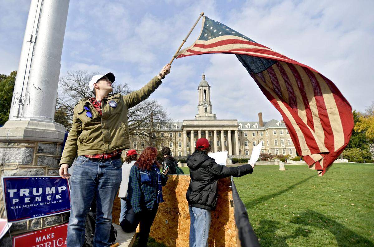 Dylan Homenic waves his 39-star flag as he and fellow Donald Trump supporters built a freedom of speech wall around the American flag on Penn State’s Old Main lawn on Tuesday, Nov. 1, 2016. 