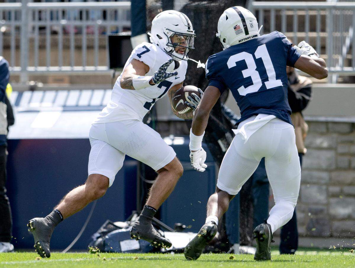 Penn State wide receiver Kaden Saunders cuts down the field with the ball from defender Colin Dinkins during the Blue-White game on Saturday, April 13, 2024.