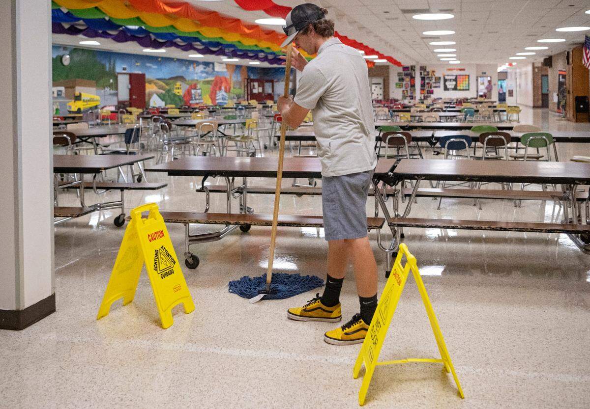 Gabe Cantolina, a custodian at Park Forest Middle School, cleans up a spill int he cafeteria on the first day of school day on Aug. 22.