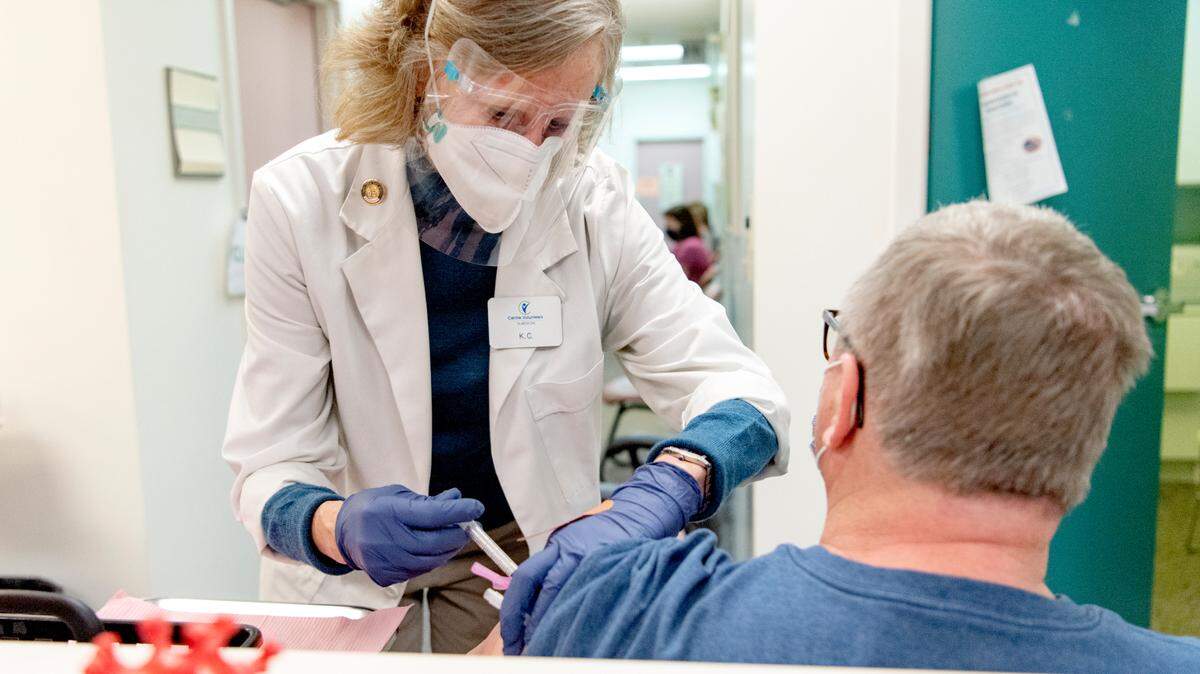 Volunteer K.C. Sheeler administers the COVID-19 vaccine to community members at Centre Volunteers in Medicine in March 2021.