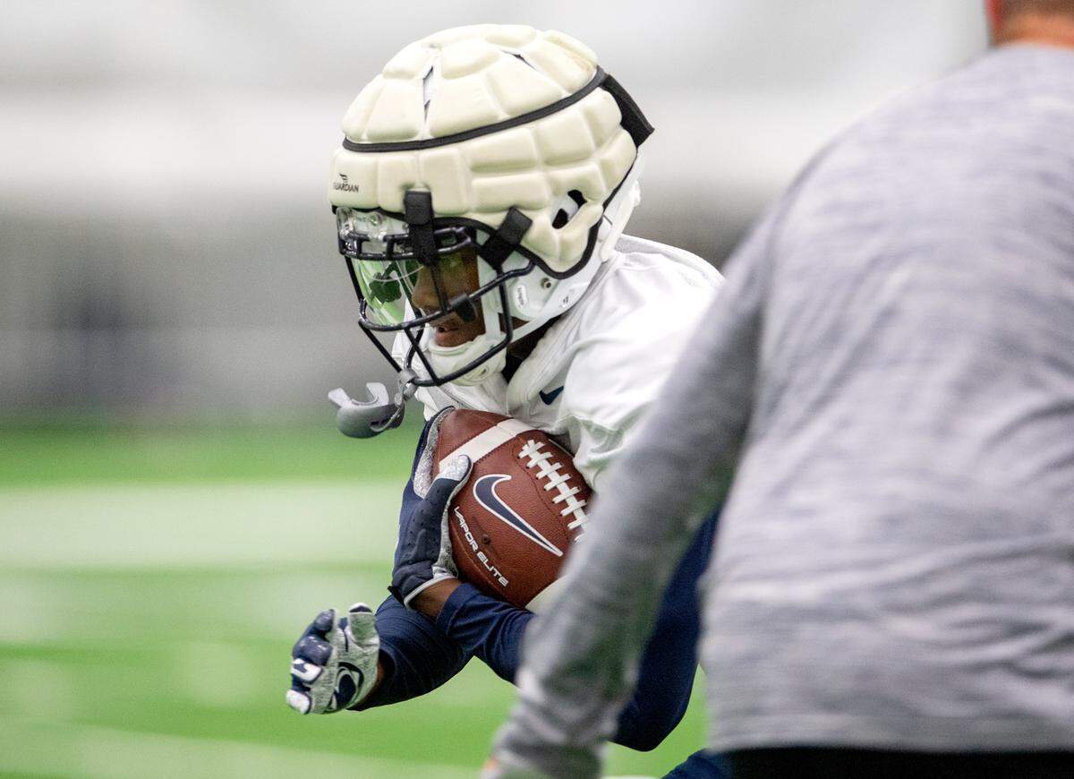 Penn State wide receiver Jahan Dotson makes a catch and cuts around a trainer during practice on Wednesday, Sept. 1, 2021 in Holuba Hall.