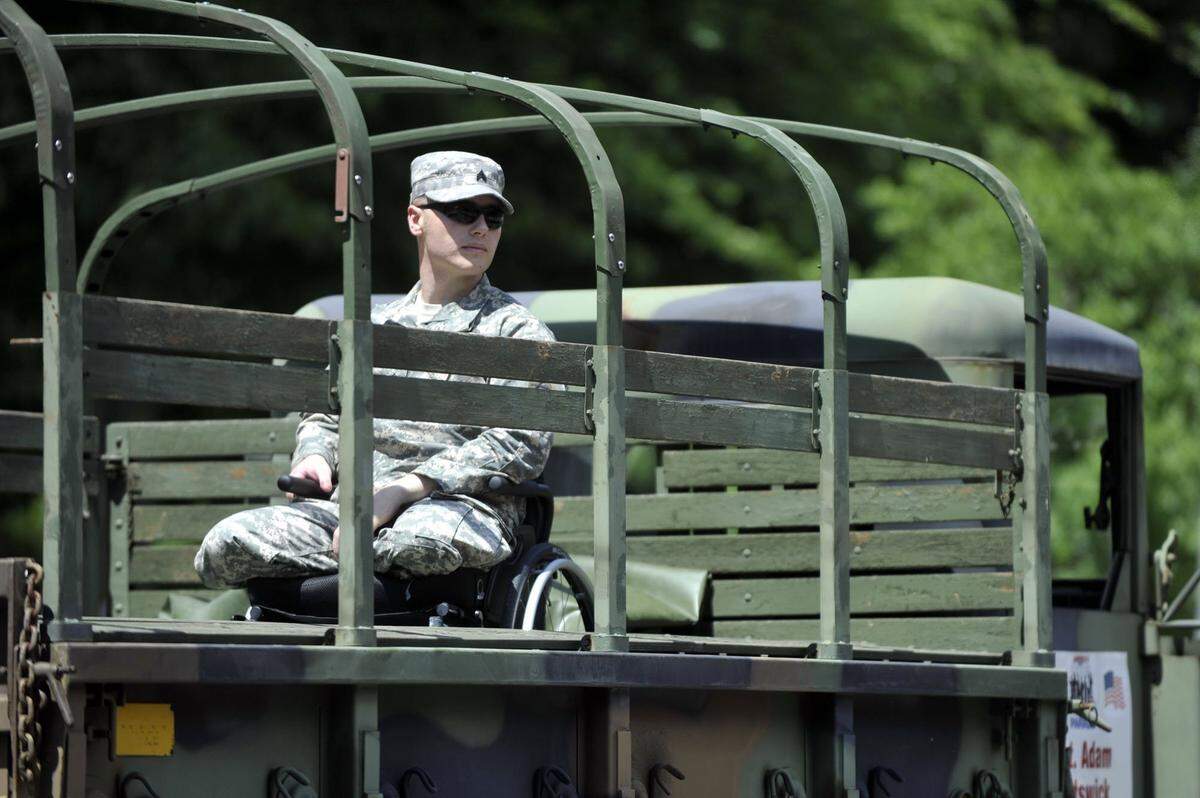 Sgt. Adam Hartswick looks out over the crowd while riding in a military truck during the 2013 4th Fest Parade of Heroes.
