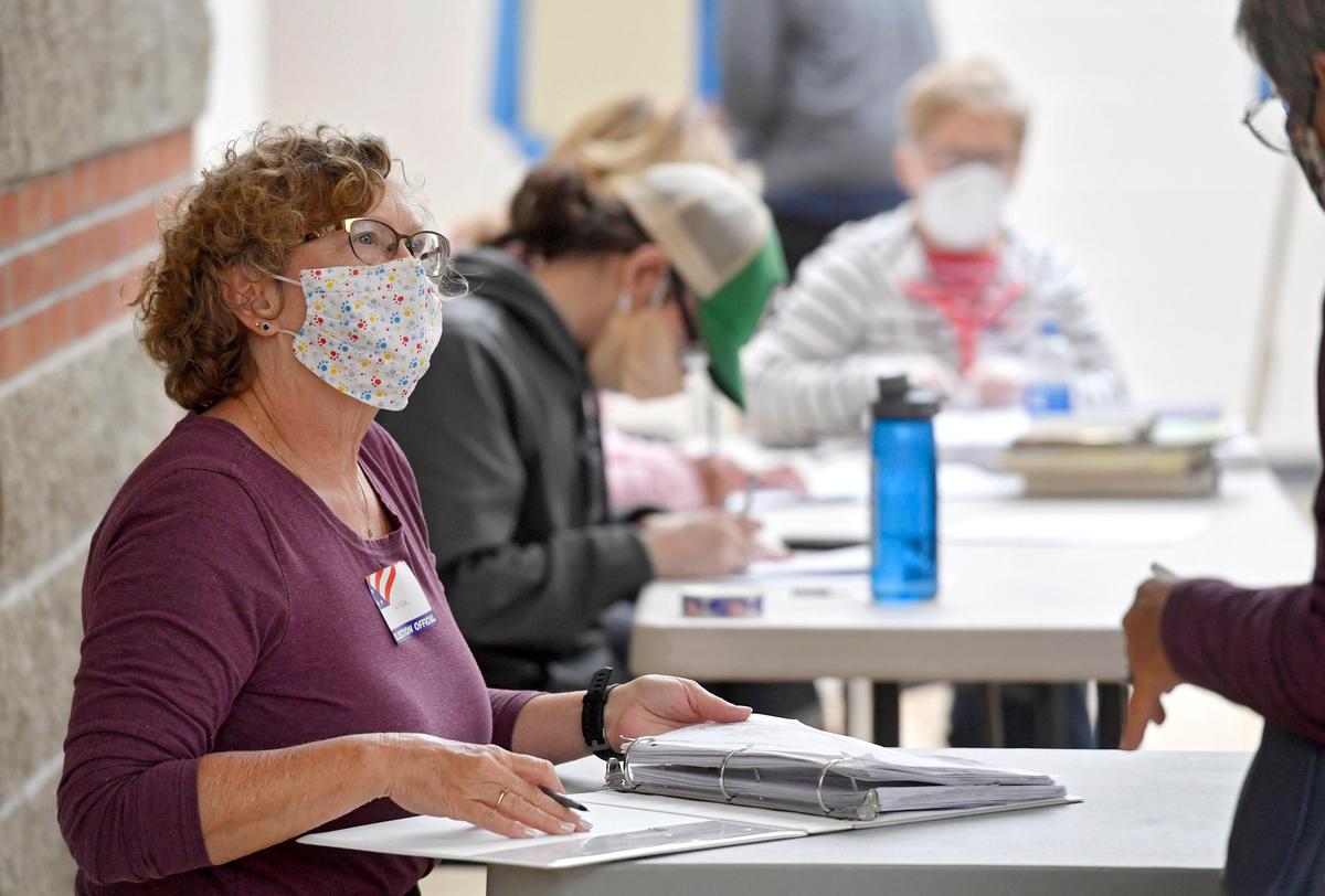 Lisa Grove checks in a voter for the primary election on Tuesday, June 2, 2020 at the precinct at the Bellefonte Middle School.